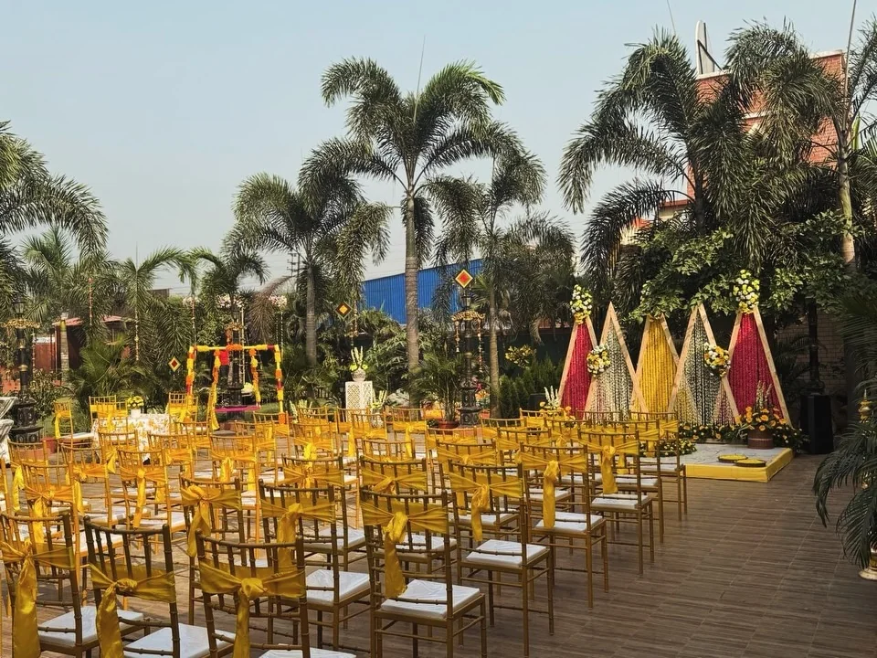 Rows of yellow-accented chairs facing an outdoor haldi setting